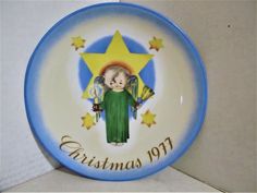 a blue and white plate with an angel holding a star on it's side