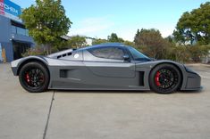 a grey sports car parked in front of a building