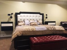 a bedroom with a large bed and leather ottomans