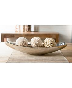 three white balls in a wooden bowl on a table