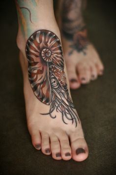 a woman's foot with an octopus tattoo on the top and bottom of it