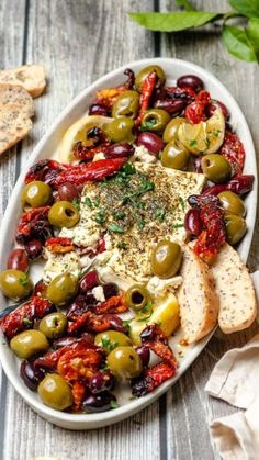 a white plate topped with olives and bread