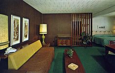 an old photo of a living room with green carpet and wood paneling on the walls