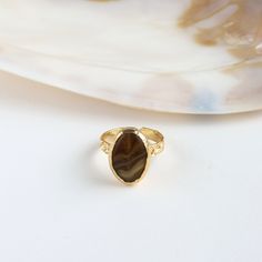 Adorn your finger with Brown Agate Ring. Handcrafted from copper and plated with 24k gold, it embodies timeless beauty. Embrace elegance with this unique, artisanal accessory that adds a touch of sophistication to your ensemble. Details: Materials: Copper, 24K Gold Plated, Agate Size: adjustable from 6 to 8 ring sizes. Nickel Free Important info: Please note that our collection is meticulously curated by a diverse array of makers and designers within friends. Be aware that for certain items, we Gold Crystal Open Ring With Polished Finish, Gold Open Crystal Ring With Polished Finish, Gold Agate Jewelry With Polished Finish, Gold Agate Cabochon Jewelry, Gold Cabochon Agate Jewelry, Adjustable Agate Open Ring Jewelry, Adjustable Agate Open Ring, Gold Round Agate Jewelry, Gold Open Ring With Cabochon Jewelry