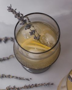 a glass filled with lemonade and ice sitting on top of a white tablecloth