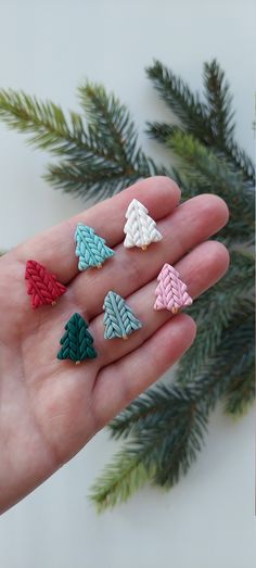 a person's hand is holding five small pieces of miniature jewelry in their palm