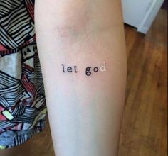 a woman's arm with the words let god tattooed on her left arm, in black ink