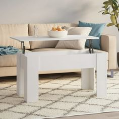 a white coffee table sitting on top of a rug in front of a beige couch