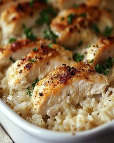 chicken and rice casserole with parsley in a white dish on a table