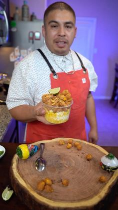 a man in an apron holding a bowl of food