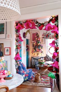 a living room decorated for christmas with pink and green decorations on the wall, white trimming