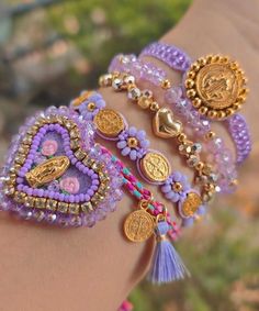 a close up of a person's arm with bracelets and charms on it