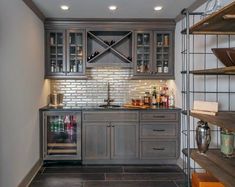 a kitchen with wooden cabinets and shelves filled with bottles, wine glasses and other items