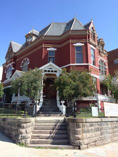 a large red building with stairs leading up to it's front door and windows