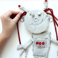 someone is making a robot ornament out of felt and beads for the decoration