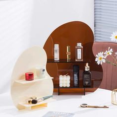 an assortment of beauty products on display in front of a mirror and vase with daisies