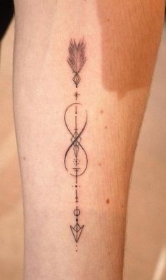 a woman's leg with an arrow tattoo on it