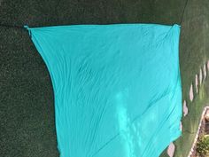 a blue tarp laying on top of a lush green field