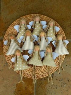 a wicker basket filled with wooden dolls on top of a table