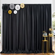 black and gold party decorations are on display in front of a backdrop with fan shaped fans