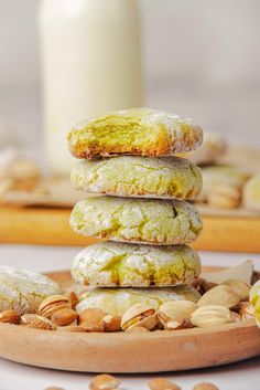 a stack of cookies sitting on top of a wooden plate next to a bottle of milk