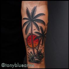 a man's arm with a palm tree and sunset tattoo on the left forearm