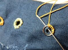 an old pair of jeans has been stitched together with some yellow thread and two holes in the fabric