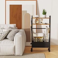 a white couch sitting next to a wooden shelf filled with books and other items on top of a hard wood floor