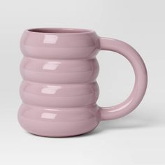 a pink coffee mug sitting on top of a white table