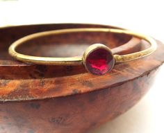 1920s Art Deco bangle bracelet This petite bangle bracelet is a real find. The bracelet is an adjustable bracelet with an integral clasp built into the bangle. The bangle has a focal red glass stone, which is faceted. The bangle is for a small wrist - 6 - 7 inches Antique Brass Round Bangle, Antique Round Brass Bangle, Vintage Red Round Bangle, Vintage Handmade Red Bangle, Vintage Brass Bangle For Gift, Vintage Red Adjustable Bangle, Antique Brass Bangle For Gifts, Antique Brass Bangle Gift, Art Deco Handmade Bracelets As Gift