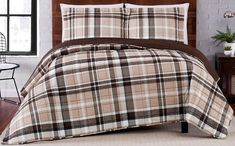 a bed in a room with a brown and white plaid comforter