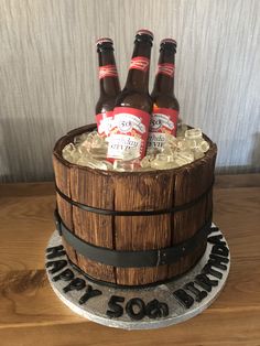 a birthday cake made to look like a barrel with beer bottles in it and ice on top