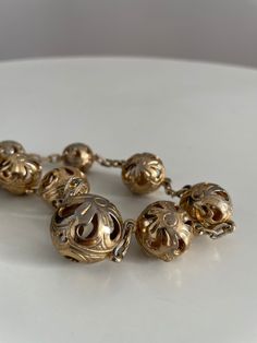 Vintage 1930s to 1940s brass necklace feature large, etched, filigree-esque balls with see-through cutouts.The balls alternate in size .  Era: 1930s -1940s Length: 20" Materials: brass , metal Condition: excellent ✩ visit the shop ✩ https://www.etsy.com/shop/Themagicstories2?ref=seller-platform-mcnav Thanks! Vintage Antique Gold Round Beads Jewelry, Antique Gold Filigree Brass Necklace, Vintage Brass Necklace With Round Beads, Vintage Metal Necklace With Etched Details, Vintage Brass Jewelry With Round Beads, Vintage Antique Gold Filigree Jewelry, Vintage Gold Filigree Necklace, Vintage Metal Necklace With Round Beads, Vintage Round Filigree Necklace