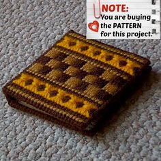 there is a small knitted object on the floor with a note attached to it