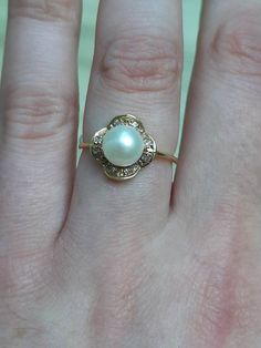 "A vintage 18ct gold cultured pearl and diamond ring. Th ring is not Hallmarked, but is stamped \"750\", and \"18K\" The round cultured pearl is set at the centre and the circumference is 7mms. The pearl is surrounded by eight round brilliant cut diamonds. The total diamond weight is approximately 0.15cts. A great quality ring which is both pretty, and elegant. Finger size N, but we can make the size bigger or smaller." Wishbone Ring, Pearl And Diamond Ring, Sapphire Pendant, Heart Pendant Diamond, Lovely Earrings, The Pearl, Diamond Heart, Round Brilliant Cut Diamond, Cultured Pearls