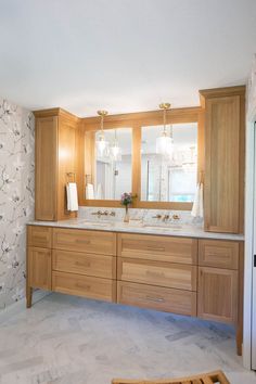 a bathroom with double sinks and wooden cabinets