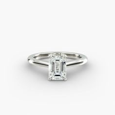 an emerald - cut diamond ring on a white background