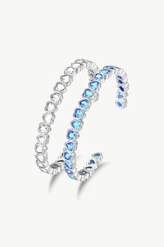 This silver bracelet set features two heart-shaped designed bangle bracelets with sparkling cubic zirconia accents, one with sky blue stones and the other with clear white stones. The heart shape symbolises love and affection, and the zirconia stones add a touch of sparkle and sophistication. The bangle bracelets are adjustable to fit any wrist size. They can be worn alone or stacked with other bracelets for a more dramatic look. This set of bangle bracelets is perfect for any outfit, special oc Bracelet Set Silver, White Stones, Bangle Bracelet Set, Blue Stones, Boot Jewelry, Ring Watch, Clear White, Mens Fragrance, Women Fragrance