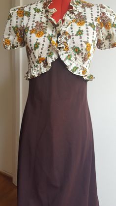 Absolutely brilliant vintage hippie boho dress. A long brown skirt and bodice with apricot flowers and puffy short sleeves very pretty and feminine and in very good vintage condition. Made from Crimplene, size 12 measures bust 34inch, waist 26inch, hip 36inch length is 150cm Hippie Brown Floral Print Dress, Fitted Brown Dresses With Ruffles, Retro Brown Dress With Ruffles, Vintage Brown Floral Print Dress, Brown Vintage Dress For Spring, Fitted Vintage Brown Maxi Dress, Fitted Brown Cottagecore Dress, Cottagecore Brown Dress For Spring, Fitted Brown Maxi Dress With Short Sleeves