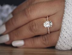 a woman's hand with a diamond ring on it