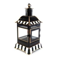 a black and white striped candle holder with a gold trimming on the top,