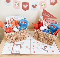 two baskets filled with toys sitting on top of a table next to a valentine's day sign