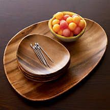 a wooden plate topped with two bowls filled with fruit next to chopsticks on top of a wooden table