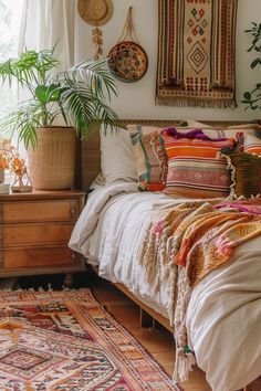 a bed with lots of pillows on top of it next to a rug and potted plants