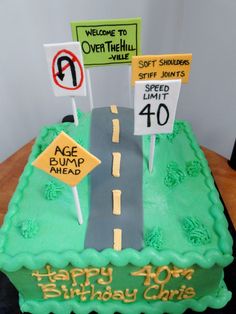 a birthday cake for a 40 year old with road signs on the side and street sign in the middle