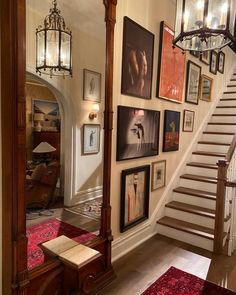 a hallway with pictures on the wall and stairs