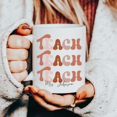 a woman holding a coffee mug with the words teach teach on it in her hands