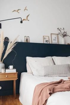 a bedroom with white bedding and black headboard