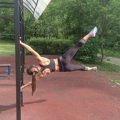 a woman hanging upside down on a pole