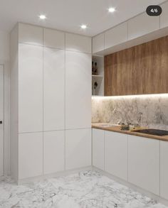 a kitchen with marble counter tops and white cupboards on either side of the sink